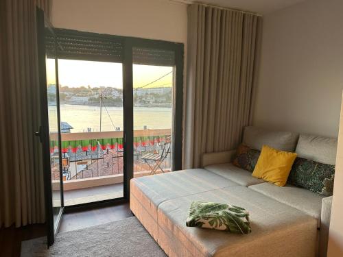 een slaapkamer met een bed en een balkon met uitzicht bij Trihouse Douro and Sea View in Vila Nova de Gaia