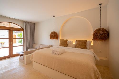 a bedroom with a large bed and a couch at Luna Kai Villas in Uluwatu