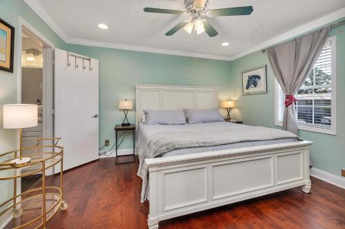 una camera con letto bianco e ventilatore a soffitto di Island Square #808 a Island Retreat