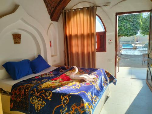 een slaapkamer met een bed met een witte slang erop bij Villa River Nile in Al Qurnah