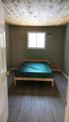 a bedroom with a bed in a room with a window at Meadowlark Cabin #5 in Maynooth