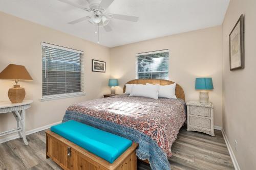a bedroom with a bed and two windows at 1055 College in Saint Simons Island