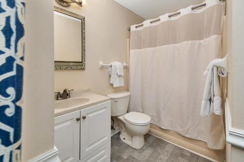 a bathroom with a toilet and a sink and a mirror at 1055 College in Saint Simons Island
