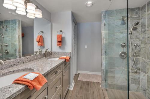 a bathroom with a shower and a sink at Beach Club #211 in East End