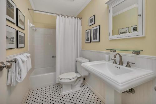 a white bathroom with a sink and a toilet at 545 Beachview Dr in Saint Simons