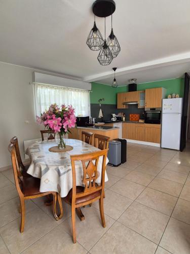 een keuken met een tafel met daarop een vaas met bloemen bij Chez Carisa in Puilboreau