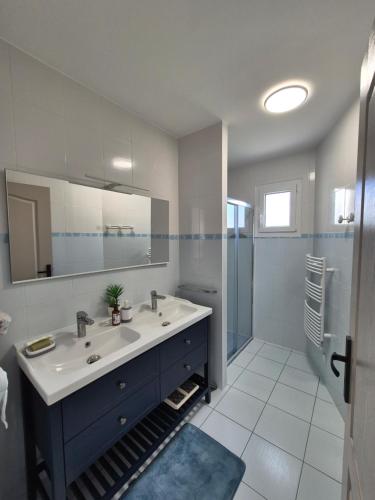 een badkamer met een wastafel en een spiegel bij Chez Carisa in Puilboreau