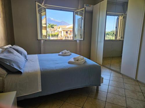 een slaapkamer met een bed met twee handdoeken erop bij Tra Onde e Vette in San Leonardello