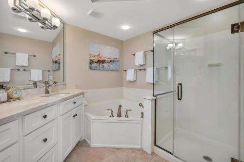 a white bathroom with a shower and a sink at St. Simons Grand #325 in East End