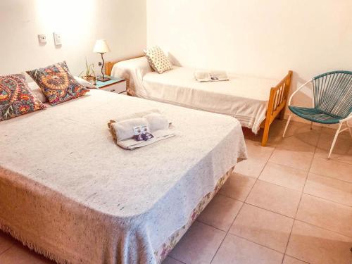 een hotelkamer met twee bedden en een stoel bij Che in Necochea