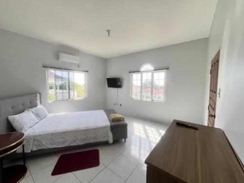 LyssonsにあるThe Retreatのベッドとテーブルと窓のある寝室