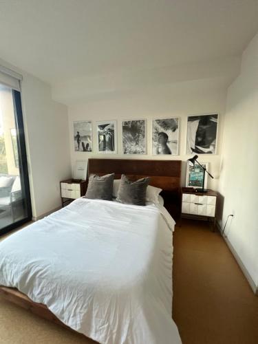 a bedroom with a white bed with pictures on the wall at Center of Hollywood in Los Angeles