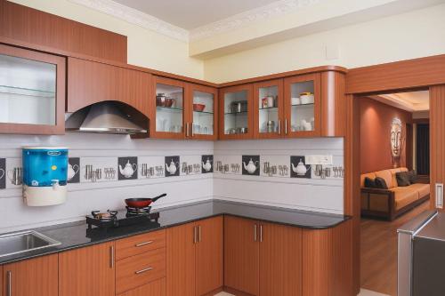 eine Küche mit Holzschränken und einem Herd in der Unterkunft Vensa corporate Inn in Bhubaneshwar