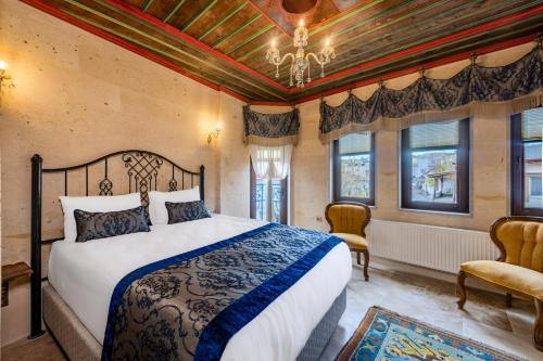una camera con letto, lampadario a braccio e finestre di Erbelya Cappadocia House a Göreme