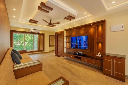 ein Wohnzimmer mit Sofa und Flachbildfernseher in der Unterkunft Vensa corporate Inn in Bhubaneshwar