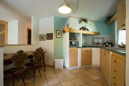 una cucina con un bancone, un tavolo e delle sedie di Casa Fam.Barbolini a Tesero