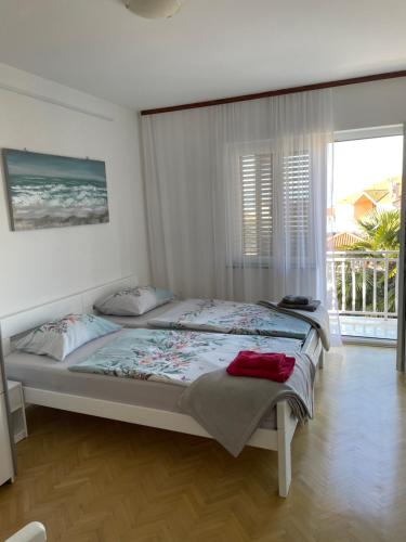 a bedroom with a bed and a large window at Casa Estancia Apartment in Njivice