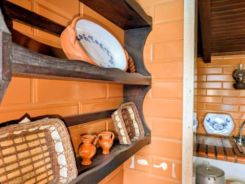 ein Regal mit Platten und Vasen an einer Wand in der Unterkunft Onda Atlântica - Atlantic Wave Peniche in Peniche