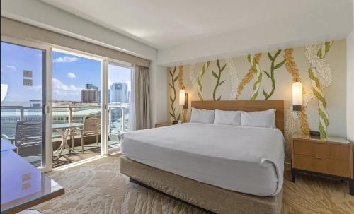 Un dormitorio con una cama grande y un balcón. en Ala Moana Condo, en Honolulu