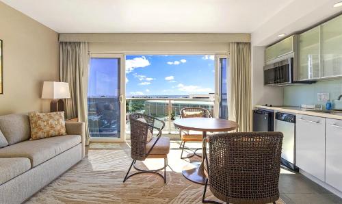 a living room with a couch and a table with chairs at Ala Moana Condo Hotel in Honolulu