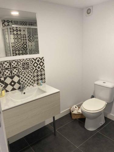 a white bathroom with a toilet and a sink at Casa Água in Lamas