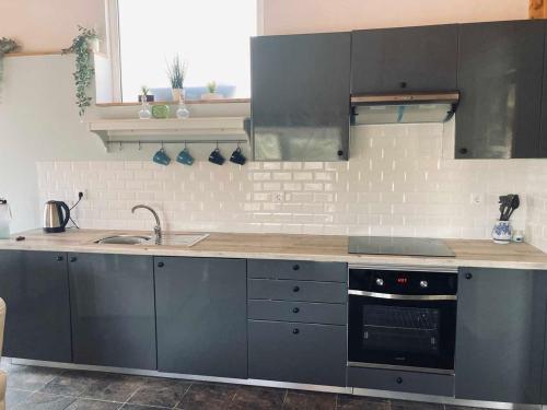 a kitchen with gray cabinets and a sink and a stove at Casa Água 