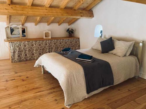 a bedroom with a bed in a room with wooden floors at Casa Água 