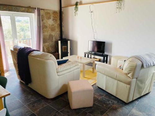 a living room with two chairs and a table at Casa Água