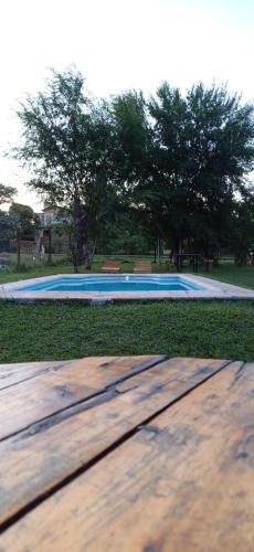 un tavolo in legno di fronte alla piscina di Cabaña Benitto a Potrero de Garay