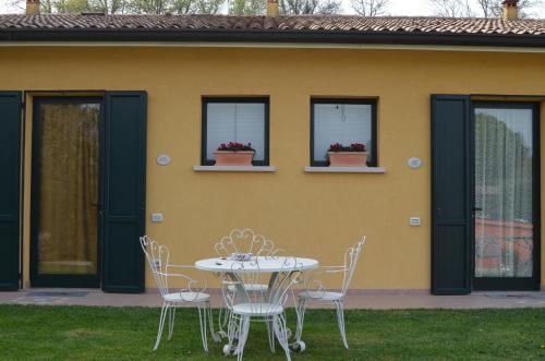 a table and chairs in front of a yellow house at Agriturismo Dondino in Cavriana