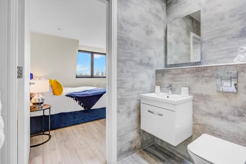 a bathroom with a sink and a toilet and a bed at Hybrid Resi - London, Sutton, FREE on-site Car or Van parking in Cheam