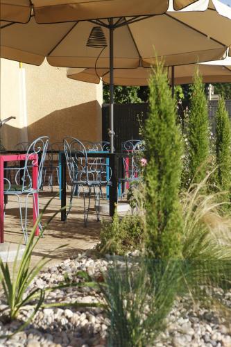 a patio with tables and chairs and an umbrella at Auberge Bressane de Buellas in Buellas