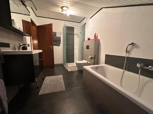 een badkamer met een bad, een toilet en een wastafel bij Apartment Rosi SECONDO in Reisbach