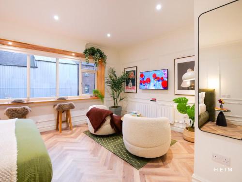 a bedroom with a bed and a living room at Ember at The Heim Residences in Manchester