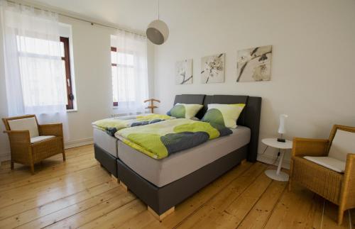 um quarto com uma cama e uma cadeira em Haus zur Pulvermühle em Zwenkau