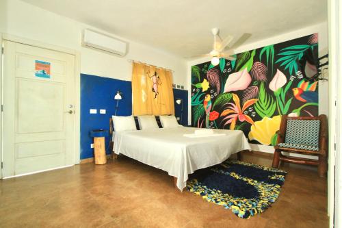 a bedroom with a bed with a painting on the wall at Brisa de Alma Guesthouse in Bayahibe