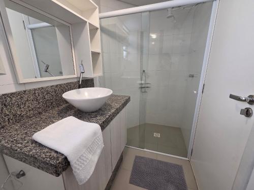 a white bathroom with a sink and a shower at Res Mariscal em Bombinhas in Canto Grande