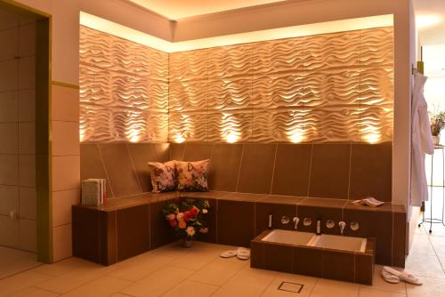 ein Badezimmer mit einer braunen Wand mit Fliesen und einem Waschbecken in der Unterkunft Romantik Hotel Fischerwiege in Ahrenshoop