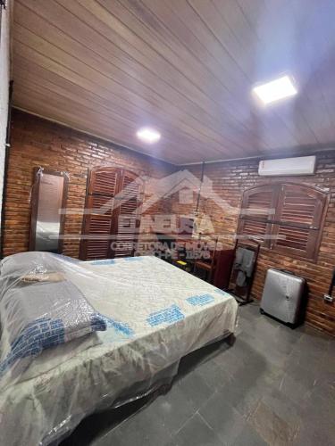 una camera da letto con un letto e un muro di mattoni di Chácara passárgada a Gravatá