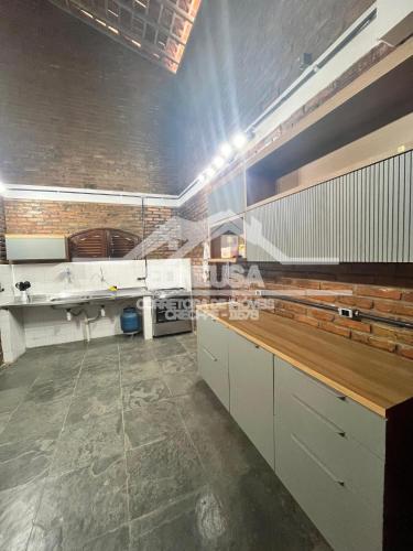 una cucina con mobili bianchi e pavimento piastrellato di Chácara passárgada a Gravatá