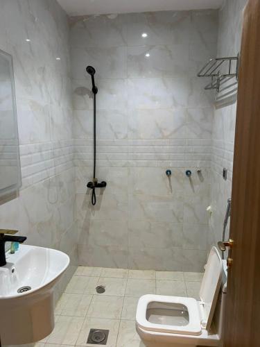 a bathroom with a shower and a toilet and a sink at شقق المحمدية - Al Mohammadia apartment in Jeddah