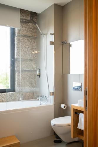 a bathroom with a shower and a toilet and a tub at Oakstone Hills in Nelas