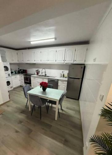 a kitchen with a table and a kitchen with white cabinets at Alvarenga House in Maia