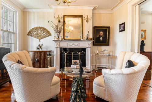 a living room with two chairs and a fireplace at Miss Murphy's High Street Inn in Galena
