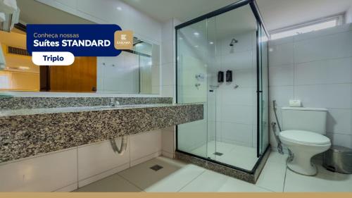 a bathroom with a glass shower and a toilet at Hotel Caiçara João Pessoa in João Pessoa