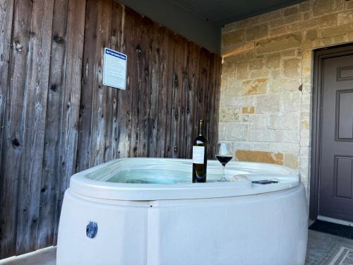 una vasca idromassaggio con una bottiglia di vino e un bicchiere di vino di NEW Pickleball, Cornhole, Pool, Patio & Hot Tub a Fredericksburg
