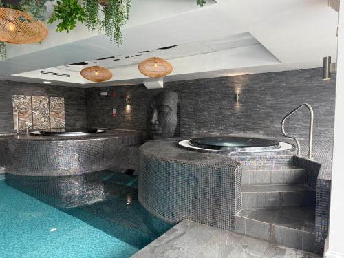 Un baño con dos bañeras de hidromasaje en una pared de ladrillo. en Beech Hill Hotel & Spa, en Windermere