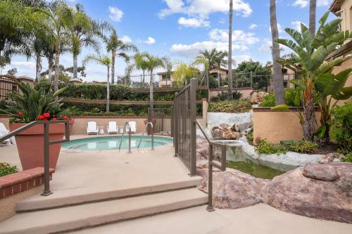 a swimming pool in a resort with palm trees at Stylish 1BR with KING Bed, Pool, Jacuzzi & Gym, Free Parking, Near UCSD in San Diego