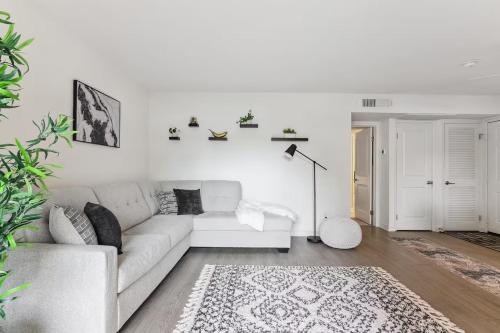 a white living room with a white couch and a rug at Stylish 1BR with KING Bed, Pool, Jacuzzi & Gym, Free Parking, Near UCSD in San Diego