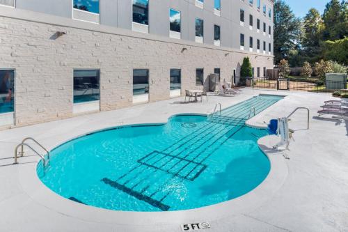 a swimming pool in front of a building at Holiday Inn Express & Suites Memphis Arpt Elvis Presley Blv by IHG in Memphis